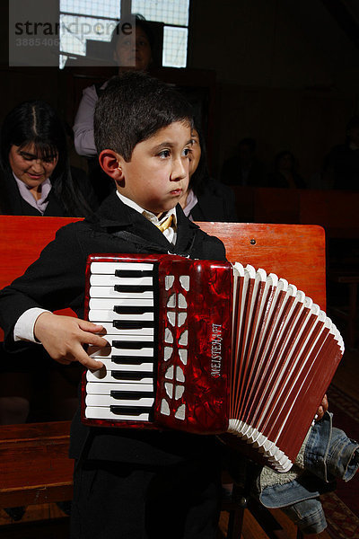 Junge spielt Ziehharmonika  Gottesdienst  Bergbaustadt Lota  Chile  Südamerika