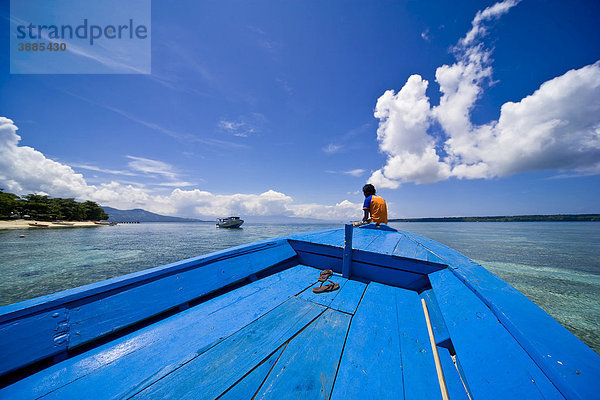 Junge Frau sitzt am Bug eines Holzboots  Siladen Insel  Sulawesi  Indonesien  Südostasien