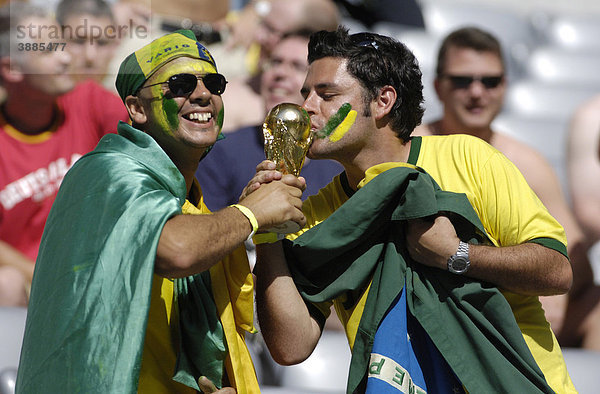 Brasilianische Fußballfans küssen ein Modell des WM-Pokals  Fußball WM 2006 in Deutschland