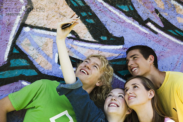 Teenagerin fotografiert sich mit Freunden auf dem Handy