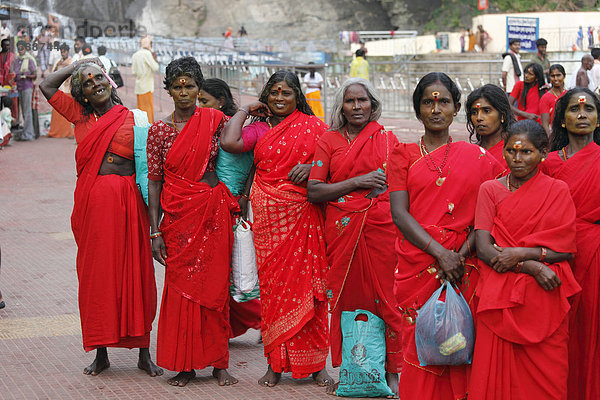 Gruppe von indischen Frauen in roten Saris  Kutralam Wasserfälle  Kuttralam  Kuttalam  Courtallam  Tamil Nadu  Tamilnadu  Südindien  Indien  Asien
