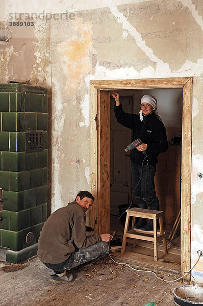 Zwei junge Leute beim Abbrennen eines alten Türrahmens in einem alten Gutshaus  Othenstorf  Mecklenburg-Vorpommern  Deutschland  Europa