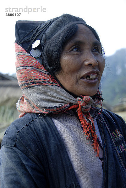 Portrait  Frau der Akha Phixor Ethnie lächelt  traditionelle Kleidung gefärbt mit Indigo  Kopfschmuck  Haube mit Silbermünzen  Dorf Ban Bounpiang  Distrikt Boun Neua  Provinz Phongsali  Laos  Südostasien  Asien
