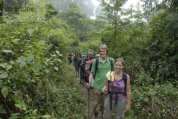 Trekking  lächelnde westliche Touristen mit Frauen der Akha Nuqui Ethnie auf Dschungelpfad  bei Ban Phou Yot  Distrikt und Provinz Phongsali  Laos  Südostasien  Asien