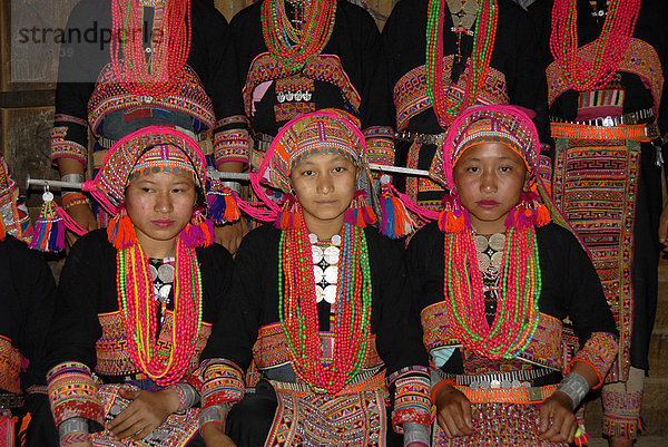 Gruppenaufnahme  junge Frauen der Akha Pala Ethnie  traditionelle schwarze Kleidung bunt bestickt  bunter Kopfschmuck  rote Halsketten  Dorf Ban Hongleuk  Distrikt Muang Khoua  Provinz Phongsali  Laos  Südostasien  Asien