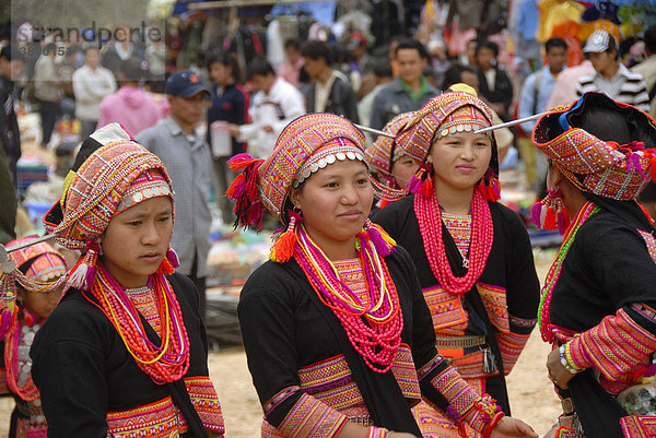 Mädchen der Akha-Pala-Ethnie  bunte traditionelle Kleidung  rosa Halsketten  Kopfschmuck bunter Turban mit Silbermünzen  Markt von Pak Nam Noi  Distrikt Muang Khoua  Provinz Phongsali  Laos  Südostasien  Asien