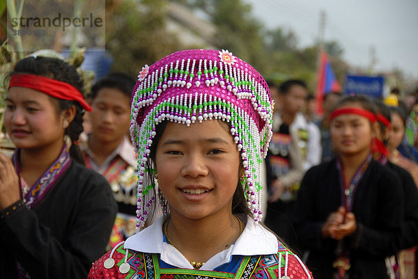 Portrait  Mädchen der Hmong-Ethnie lächelt  traditionelle Kleidung  bunter Kopfschmuck  Parade beim Elephant Festival  Ban Viengkeo  Hongsa  Provinz Xaignabouri  Sayaburi  Xayaburi oder Sainyabuli  Laos  Südostasien  Asien