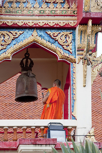 Ein Mönch läutet zum Gebet  Wat Chalong  Insel Phuket  Südthailand  Thailand  Südostasien  Asien