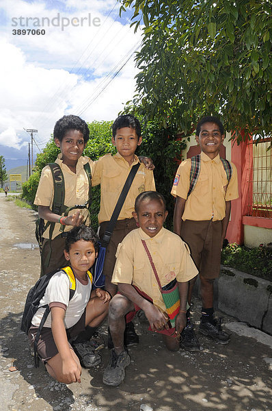 Dani und Javaner  Schüler in Schuluniform auf dem Weg zur Schule  in Wamena  Baliem Tal  Irian Jaya  Papua-Neuguinea  Indonesien  Südostasien