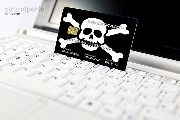 Kreditkarte mit Totenkopf am PC  Notebook  Symbolbild Gefahr des Datenmissbrauchs bei Online-Einkauf  Datenfishing  Phishing  Datenklau