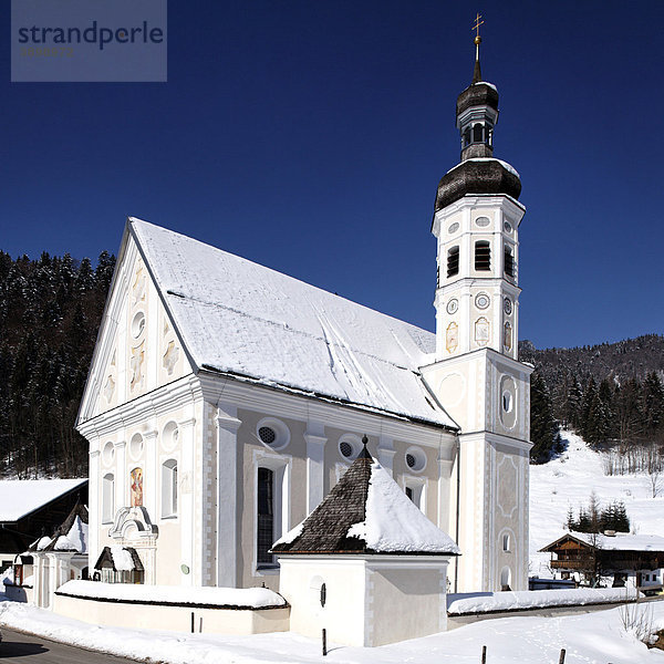 Verschneite Kirche des bayerischen Dorfs Sachrang  Oberbayern  Deutschland  Europa