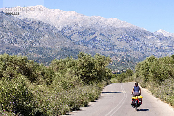 Radfahrerin auf einer Straße mit Blick auf das Weiße Gebirge  Lefka Ori  bei Vamos  Kreta  Griechenland  Europa