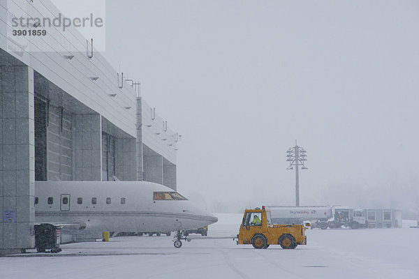 Schnee  Winter  Schlepper  Flugzeug  Hangar  General Aviation  GAT  Vorfeld  Ost  Flughafen München  MUC  Bayern  Deutschland  Europa