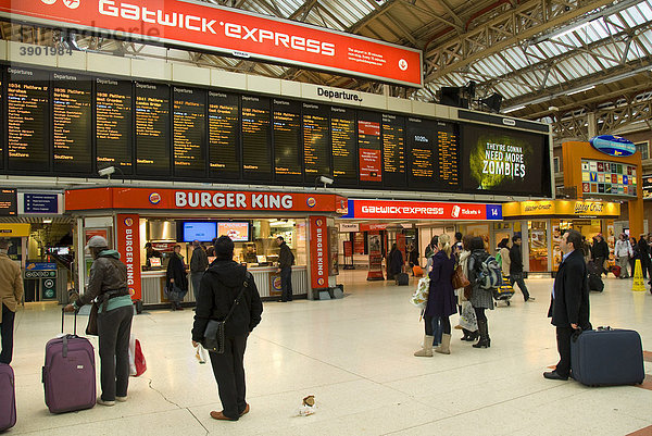 Victoria Station  Bahnhof  Haupthalle  Reisende schauen auf Anzeige  Fahrzeiten  London  England  Großbritannien  Europa
