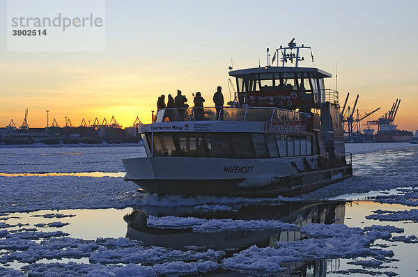 Eine Hafenfähre fährt auf der winterlichen Elbe im Hamburger Hafen bei Sonnenuntergang  Hamburg  Deutschland  Europa