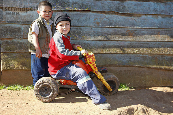 Zwei Jungen spielen mit einem Dreirad  Mapuche Indianer  bei ConcepciÛn  Südchile  Chile  Südamerika