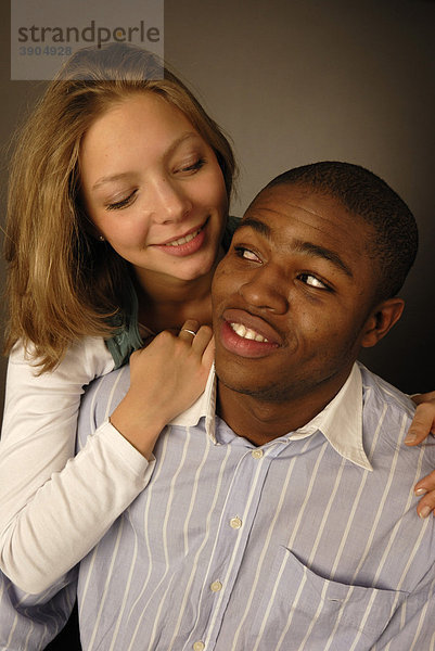 Junges verliebtes Paar  schwarze und weiße Hautfarbe  Afrikaner und Europäerin  Teenager  lächelnd