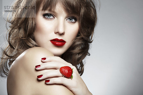 Portrait einer jungen Frau mit einem Erdbeer-Ring  Schmuck  mit einem verführerischen Blick mund