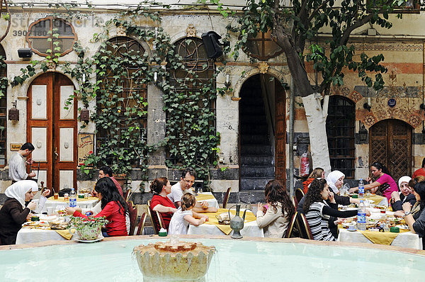 Brunnen und Gäste beim Essen im Innenhof des Restaurant Jabri House in einem alten muslimischen Palast  Altstadt von Damaskus  Syrien  Asien
