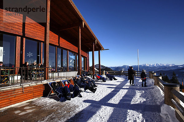 Menschen genießen die Sonne auf der Terrasse vom Sonnen-Alm Restaurant  Kampenwand  Chiemgau  Oberbayern  Deutschland  Europa