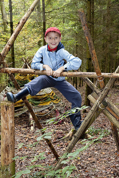 Ein Junge  7 Jahre  im Wald  klettert  Herbstzeit