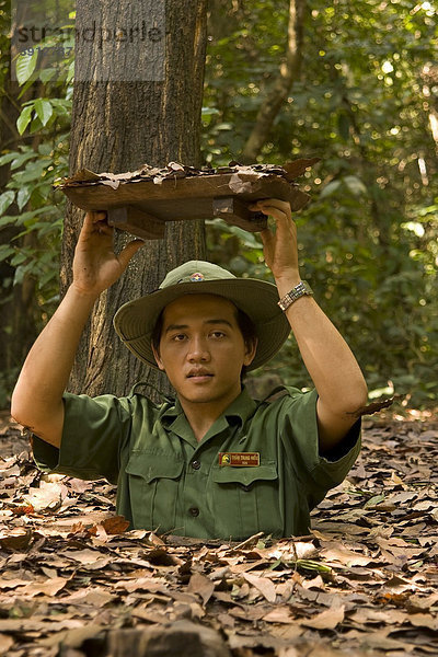 Vietnam-Soldat zeigt Eingang der Tunnelanlage in Chu Chi  Tunnelsystem des Vietkong  Vietnam  Asien