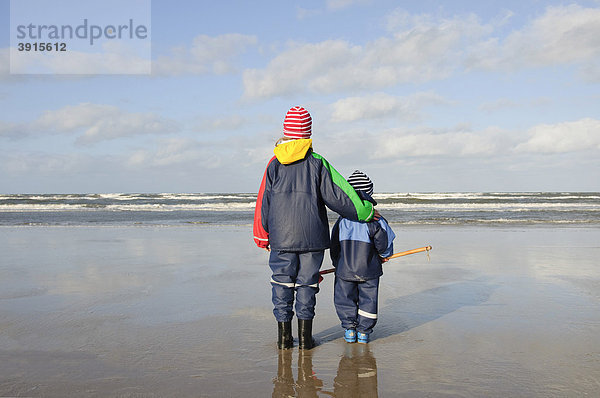 Geschwister  Mädchen  7 Jahre  und Junge  2 Jahre  stehen am Nordseestrand und schauen auf das Meer  Vejers Strand  Jütland  Dänemark  Europa