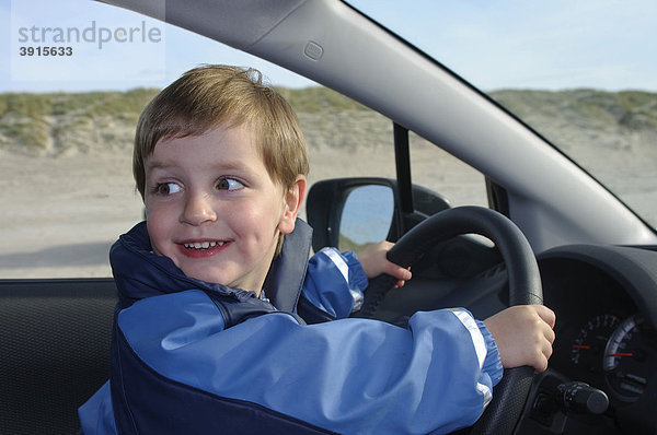 Kleiner Junge  2 Jahre  sitzt am Steuer eines Autos