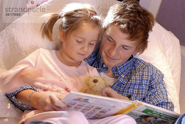 Bruder liest seiner kleinen Schwester vor  Vorlesen  Lesen  Buch lesen  Gute Nacht Geschichte