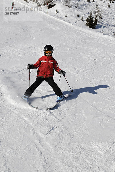 Kind beim Ski fahren  Abfahrt  Piste mit Helm  Sicherheit