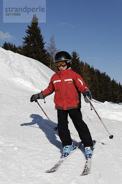 Kind beim Ski fahren  Abfahrt  Piste mit Helm  Sicherheit