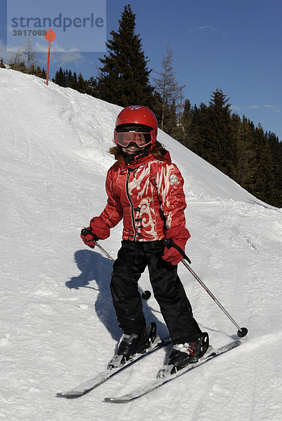 Kind beim Ski fahren  Abfahrt  Piste mit Helm  Sicherheit