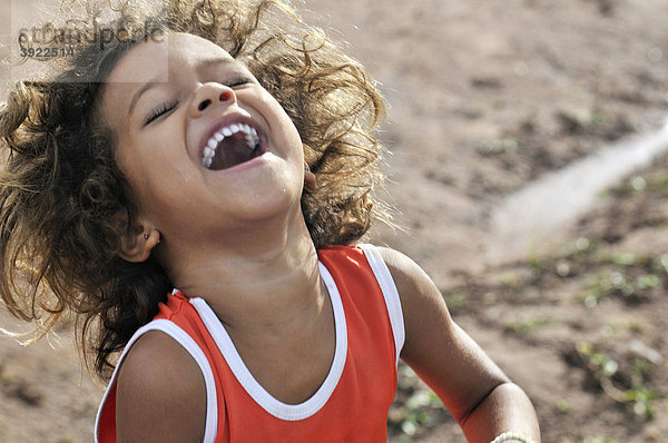 Fröhliches Mädchen lacht und tanzt  Landlosencamp Acampamento 12 de Otubro der brasilianischen Landlosenbewegung Movimento dos Trabalhadores Rurais sem Terra  MST  Munizip Claudia  Mato Grosso  Brasilien  Südamerika