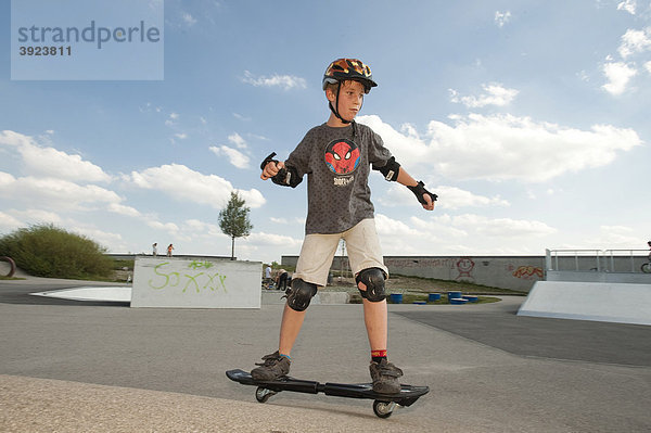 Junge  11 Jahre  mit Waveboard und Schutzausrüstung im Funpark
