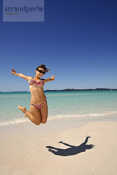Luftsprung  junge Frau am Meer  Symbolbild Lebensfreude  Schatten  Whitehaven Beach  Whitsunday Island  Whitsunday Islands Nationalpark  Queensland  Australien