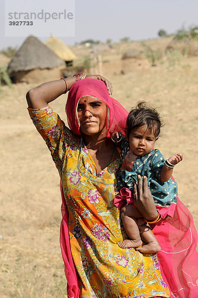 Indische Frau mit Kind vor Rundhütten  Rajasthan  Nordindien  Indien  Südasien  Asien