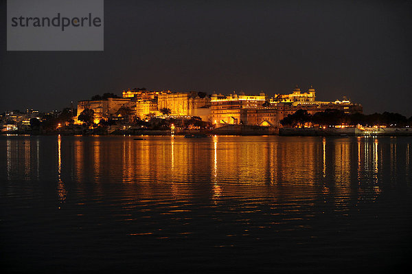 Blick über den Pichola-See auf den Stadtpalast von Udaipur bei Nacht  Udaipur  Rajasthan  Nordindien  Indien  Südasien  Asien
