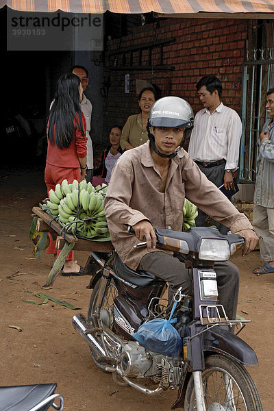 Mr. Thu bringt seine Bananenernte mit dem Moped zu Nhon  Frucht- und Gemüsehandel in Buon Ma Thuot City in Vietnam  Südostasien
