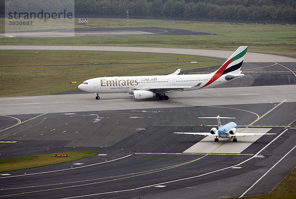 Flughafen Düsseldorf International  Emirates Airbus A330 auf dem Taxiway zur Startbahn  dahinter KLM Cityhopper Fokker 70  Düsseldorf  Nordrhein-Westfalen  Deutschland  Europa