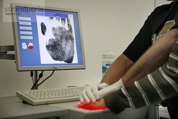 Finger- und Handabdrücke werden digital per Scanner abgenommen  erkennungsdienstliche Behandlung eines Tatverdächtigen bei der Kriminalpolizei  gestellte Szene