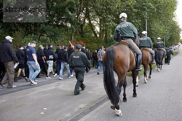 Polizeireiterstaffel beim Einsatz bei einem Fußballspiel  begleitet Fans zum Stadion  Deutschland  Europa