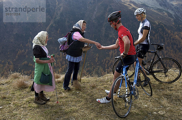 Rennrad-Fahrerin und Fahrer mit Beerenpflückerinnen an der Penserjochstraße  Südtirol  Italien  Europa