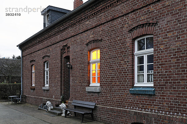 Backsteinhaus mit beleuchtetem Fenster  älteste Zechenarbeitersiedlung im Ruhrgebiet  Oberhausen Eisenheim  Nordrhein-Westfalen  Deutschland  Europa
