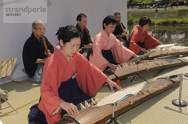 Japanerin spielt im Freien die Kodo-Zither am Kamo Ufer  Kyoto  Japan  Ostasien  Asien