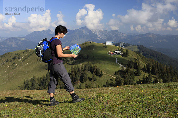 Wanderin blickt auf Wanderkarte auf der Alm  Zwieselalm  Salzkammergut  Oberösterreich  Österreich  Europa