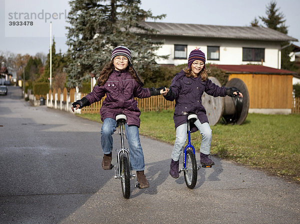 Zwei Mädchen  neun Jahre  beim Einradfahren