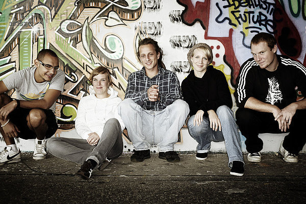 Jugendgruppe vor einer Graffitiwand  Jugendliche  Gruppe  cool