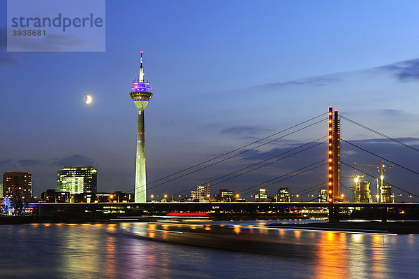 Blick vom Rheinufer über den Rhein auf die Skyline von Düsseldorf mit dem Rheinturm und Rheinkniebrücke  Nordrhein-Westfalen  Deutschland  Europa