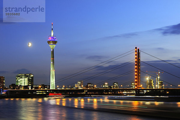 Blick vom Rheinufer über den Rhein auf die Skyline von Düsseldorf mit dem Rheinturm und Rheinkniebrücke  Nordrhein-Westfalen  Deutschland  Europa