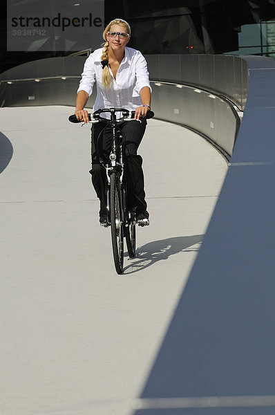 Junge Frau mit Fahrrad vor BMW-Welt  München  Bayern  Deutschland  Europa